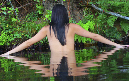 Fotografía de chica desnuda de espaldas en el agua