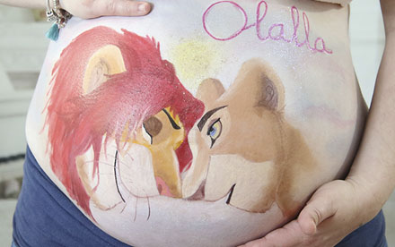 Primer plano de la barriga embarazada maquillada con mmotivo de Simba y Nala del Rey León
