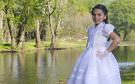 Fotografía de niña de Comunión junto a un río