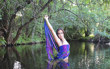 Fotografía de modelo con vestido de gasa bañándose en el río